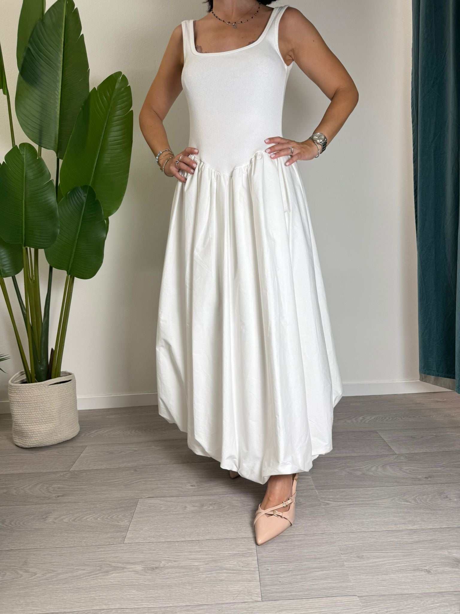 Woman wearing Abito Strega Bianco long white dress with flowy skirt and sleeveless top