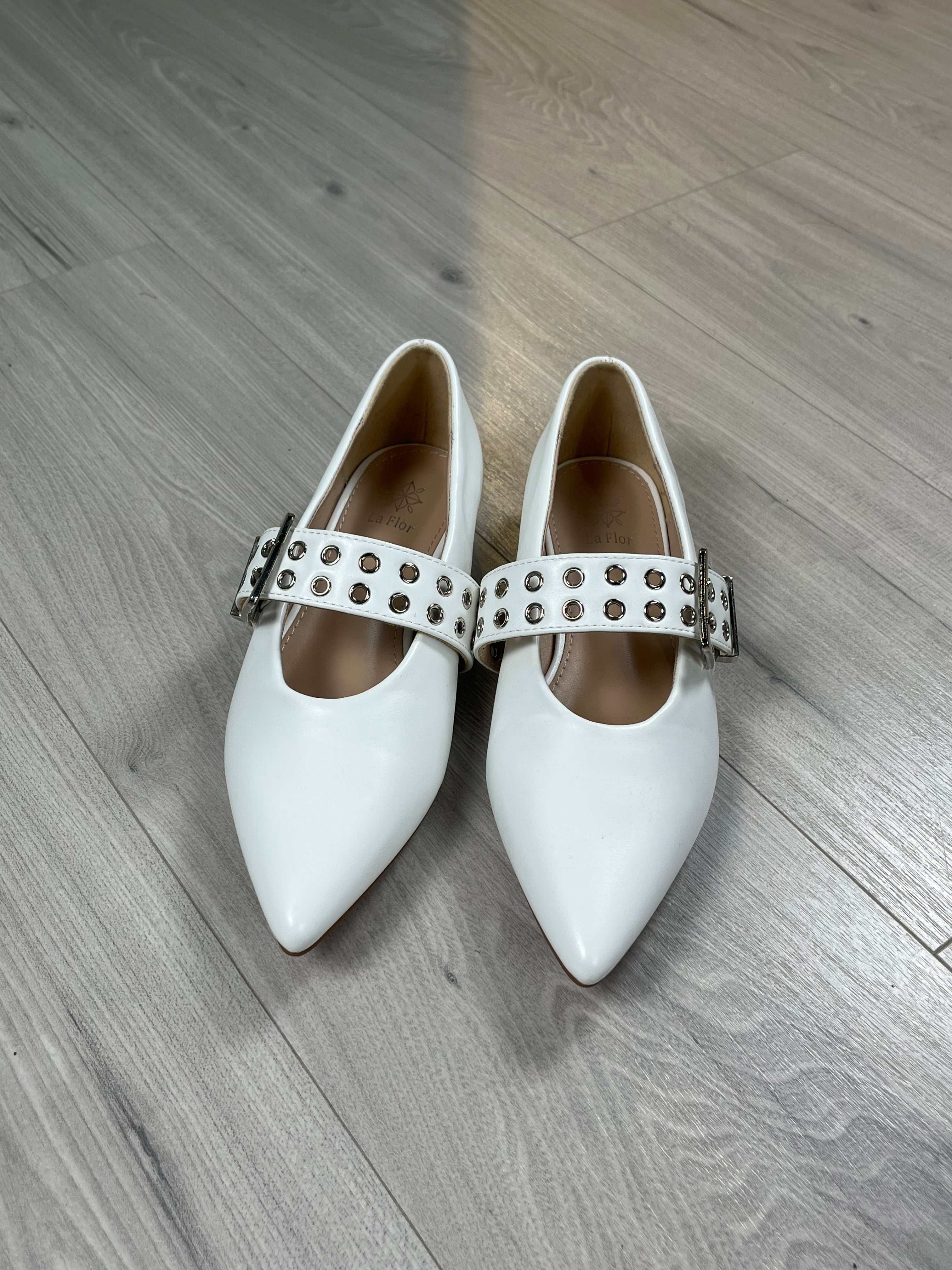 White ballerina a punta shoes with adjustable strap and regular fit on wooden floor