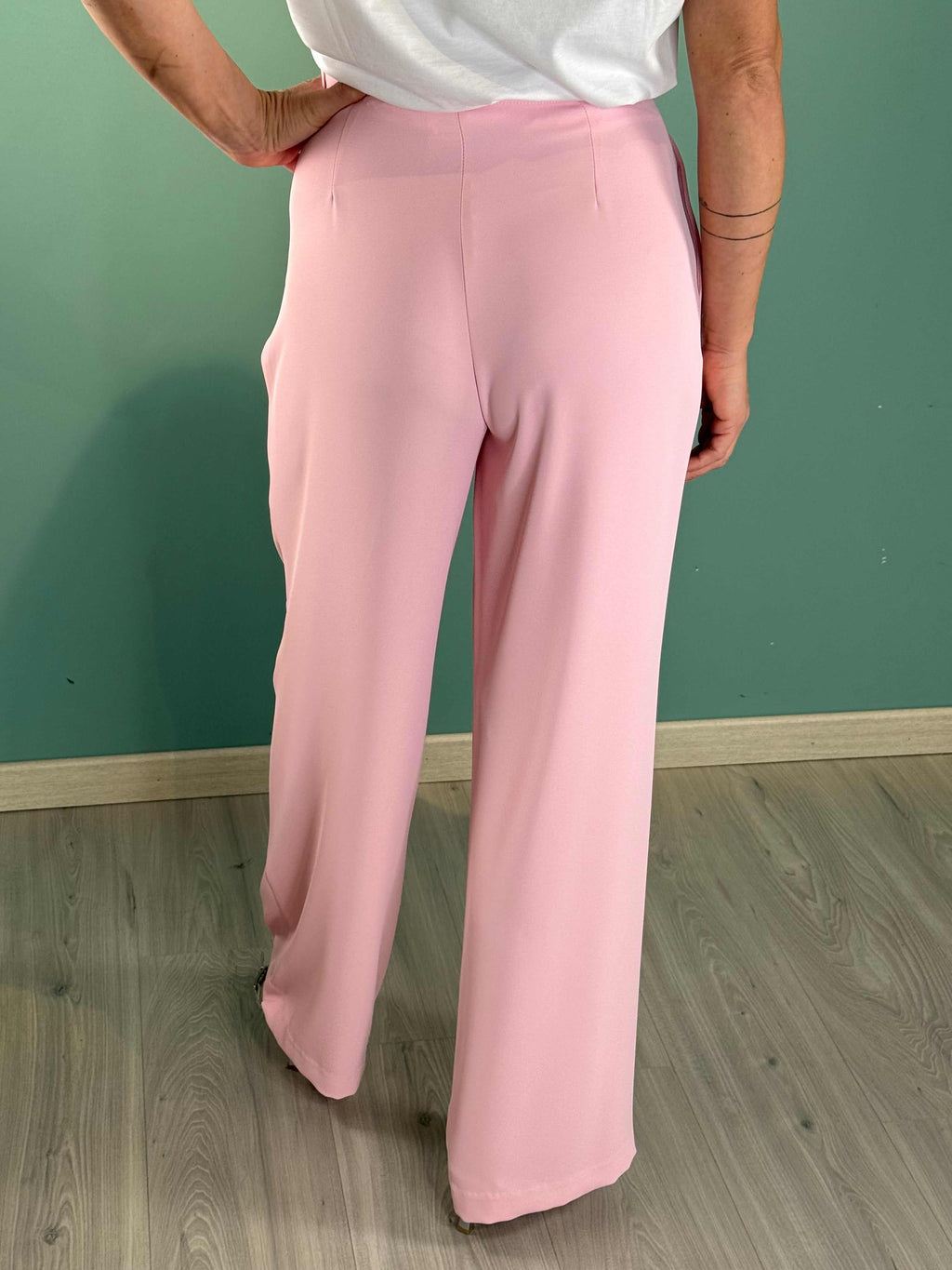 Woman wearing Pantalone Amelia Rosa Gold palazzo pants in pink with a regular fit and pleats.