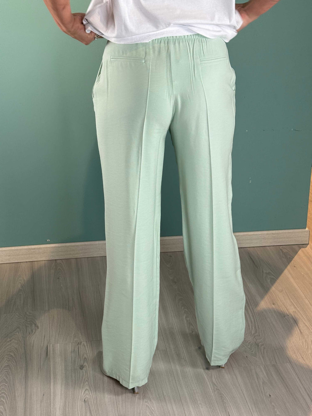 Back view of Pantalone Menta Kikisix palazzo pants with pockets in light green viscose blend fabric