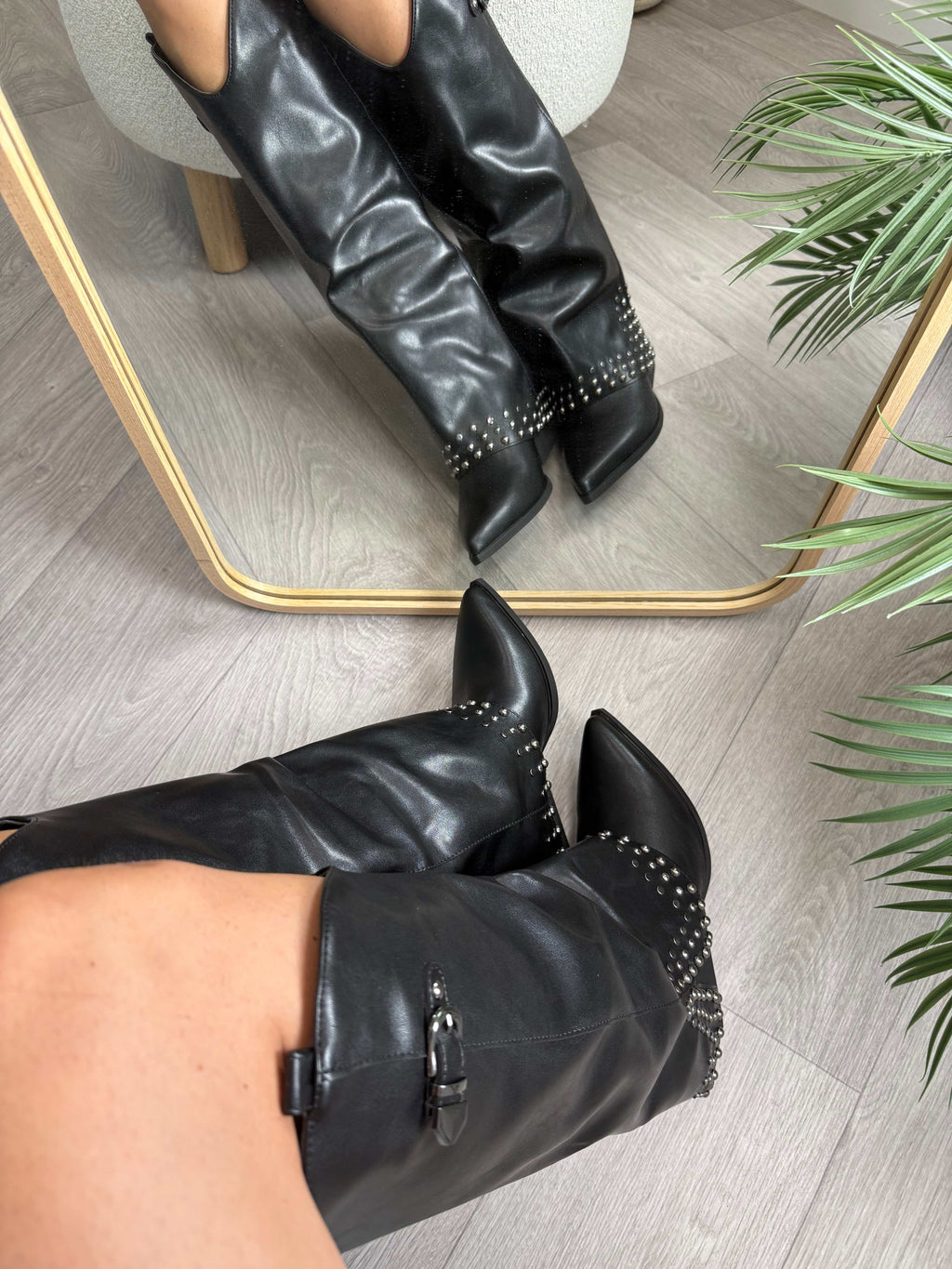 Black Texano Borchie Nero high boots with 5cm heels and stud detailing reflected in mirror on wooden floor
