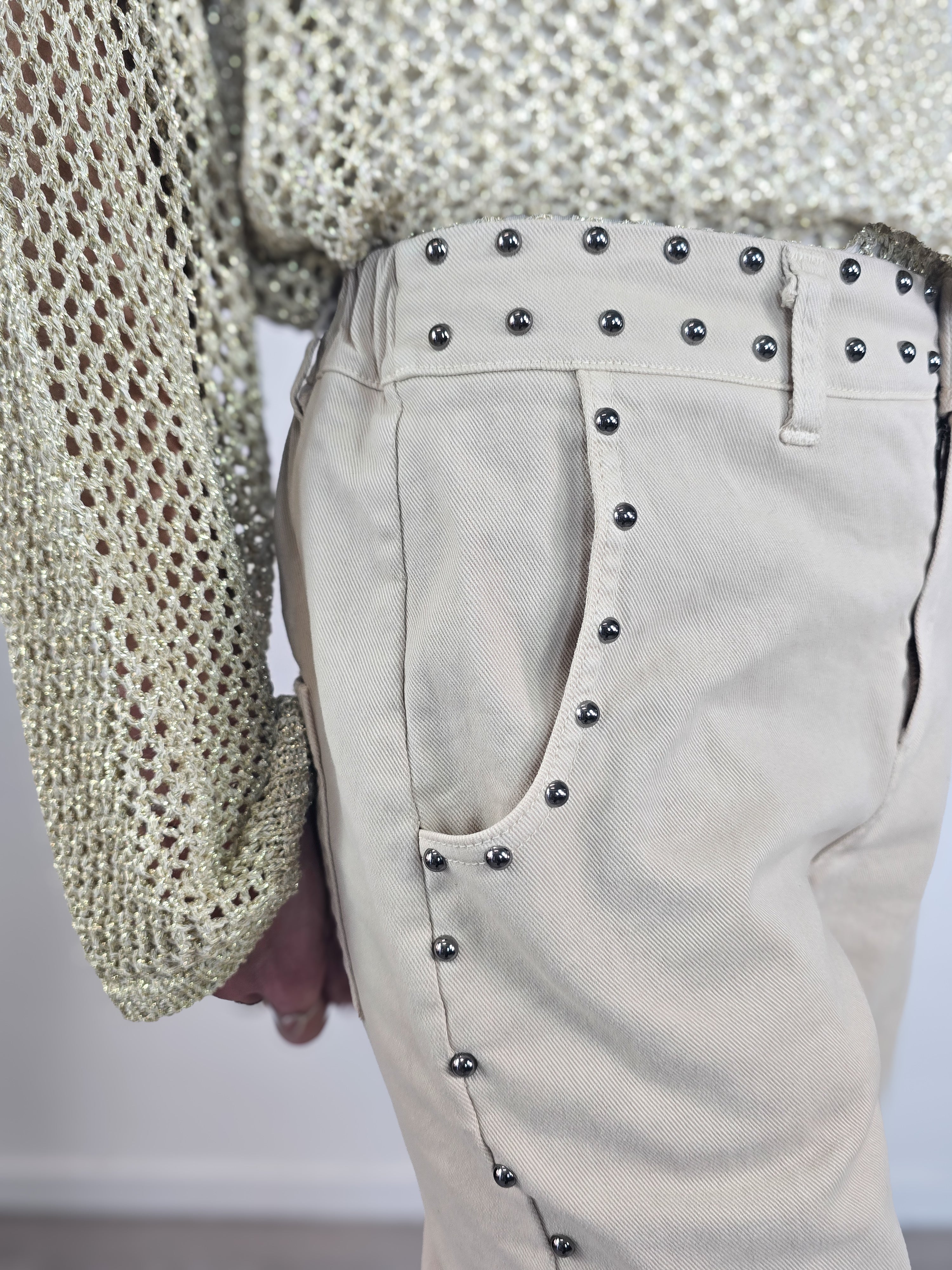 Pantaloni Kontatto modello "baloon" color beige con borchie applicate lungo i fianchi, le tasche e la vita, abbinati a décolleté nere a punta.