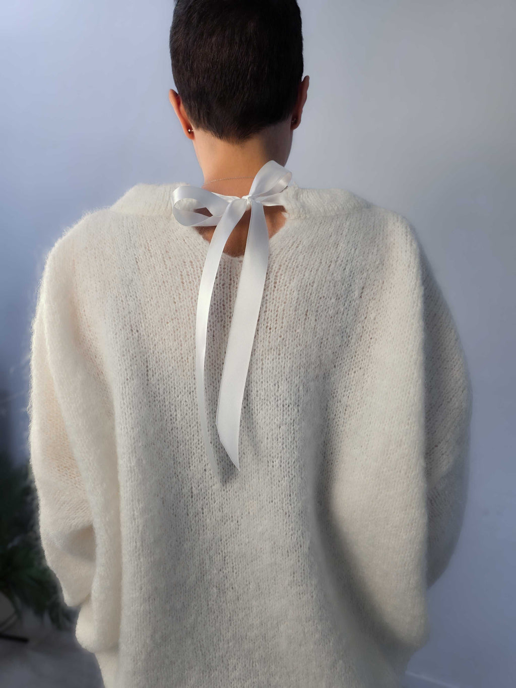 Maglione con fiocco in mohair caldo e morbido con taschino e fiocco in raso sul collo.