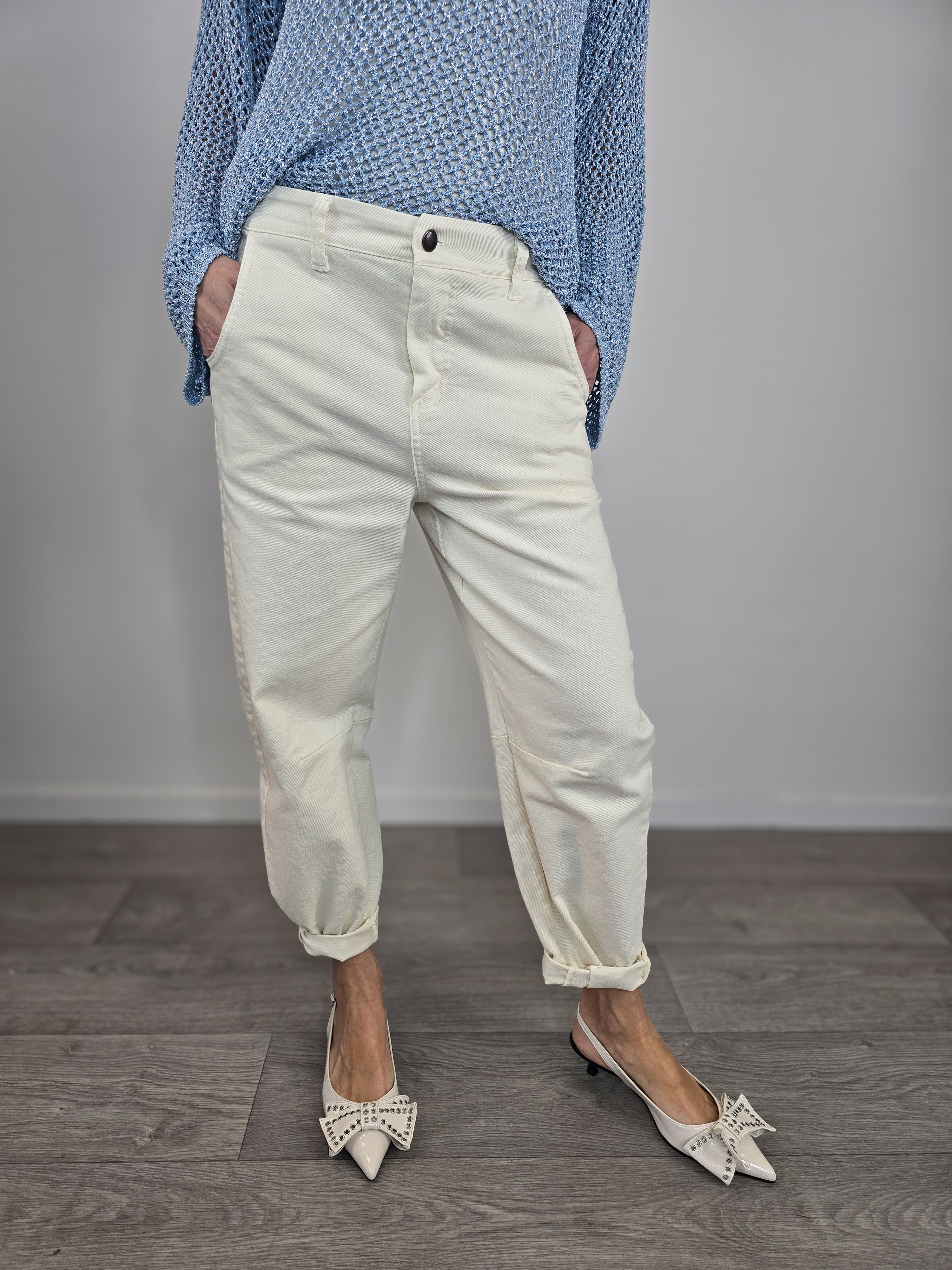 Pantaloni Kontatto modello barrel color avorio dal taglio curvo, indossati con risvolto alla caviglia e décolleté con fiocco.