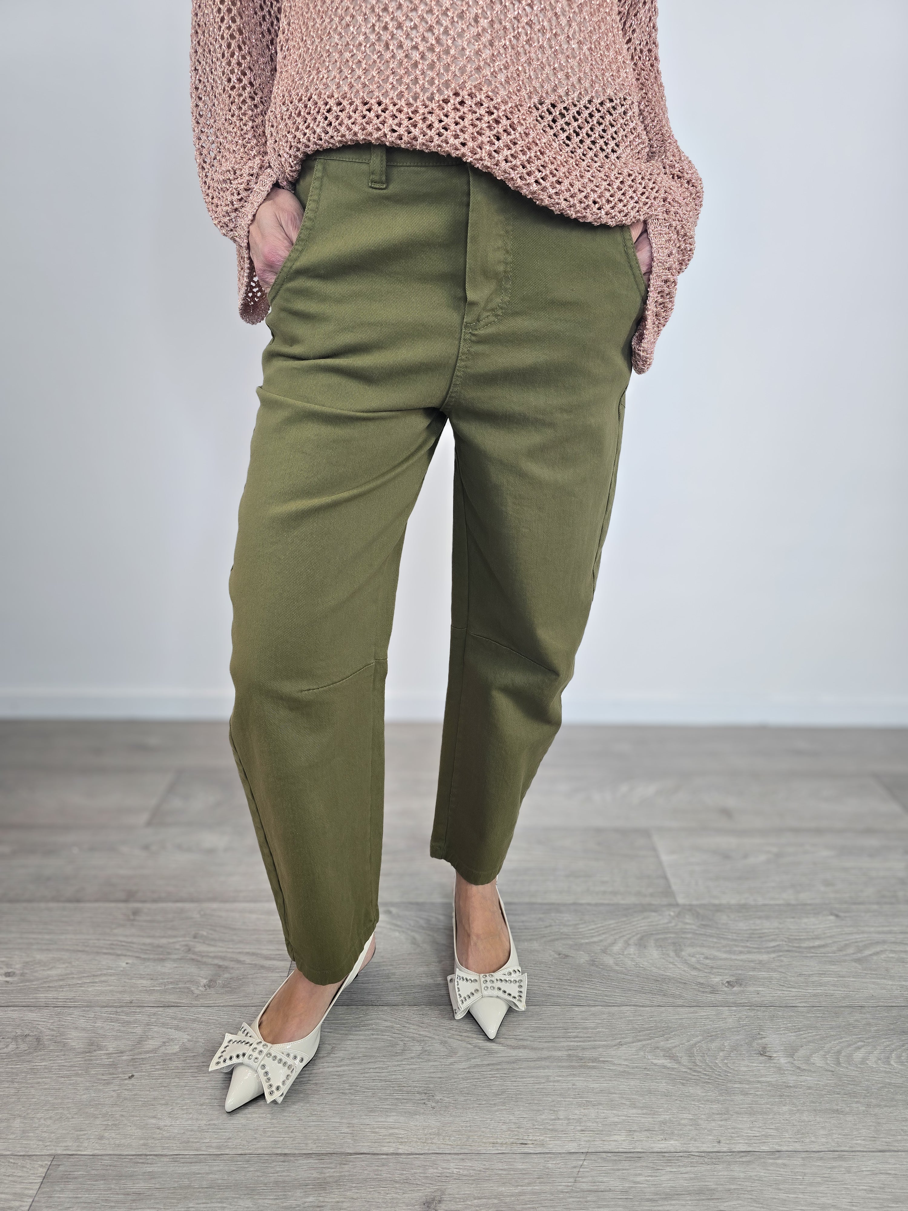Pantaloni Kontatto modello barrel color verde dal taglio curvo, indossati con risvolto alla caviglia e décolleté con fiocco.