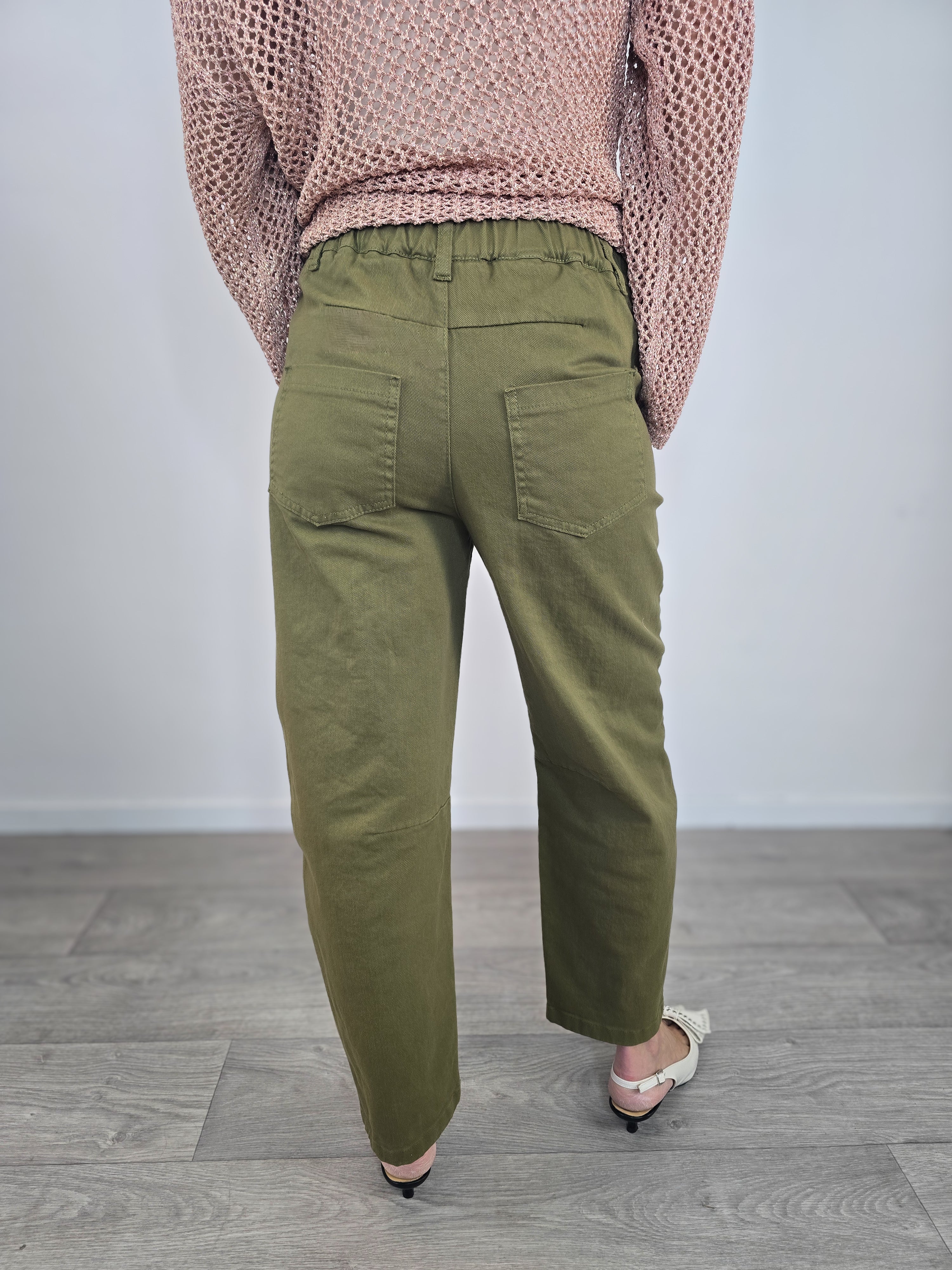 Pantaloni Kontatto modello barrel color verde dal taglio curvo, indossati con risvolto alla caviglia e décolleté con fiocco.