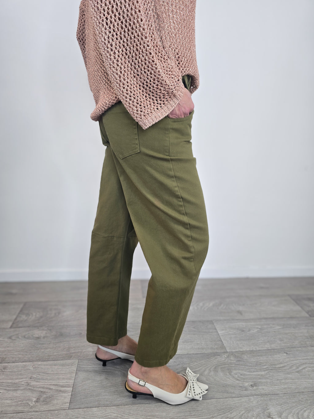 Pantaloni Kontatto modello barrel color verde dal taglio curvo, indossati con risvolto alla caviglia e décolleté con fiocco.
