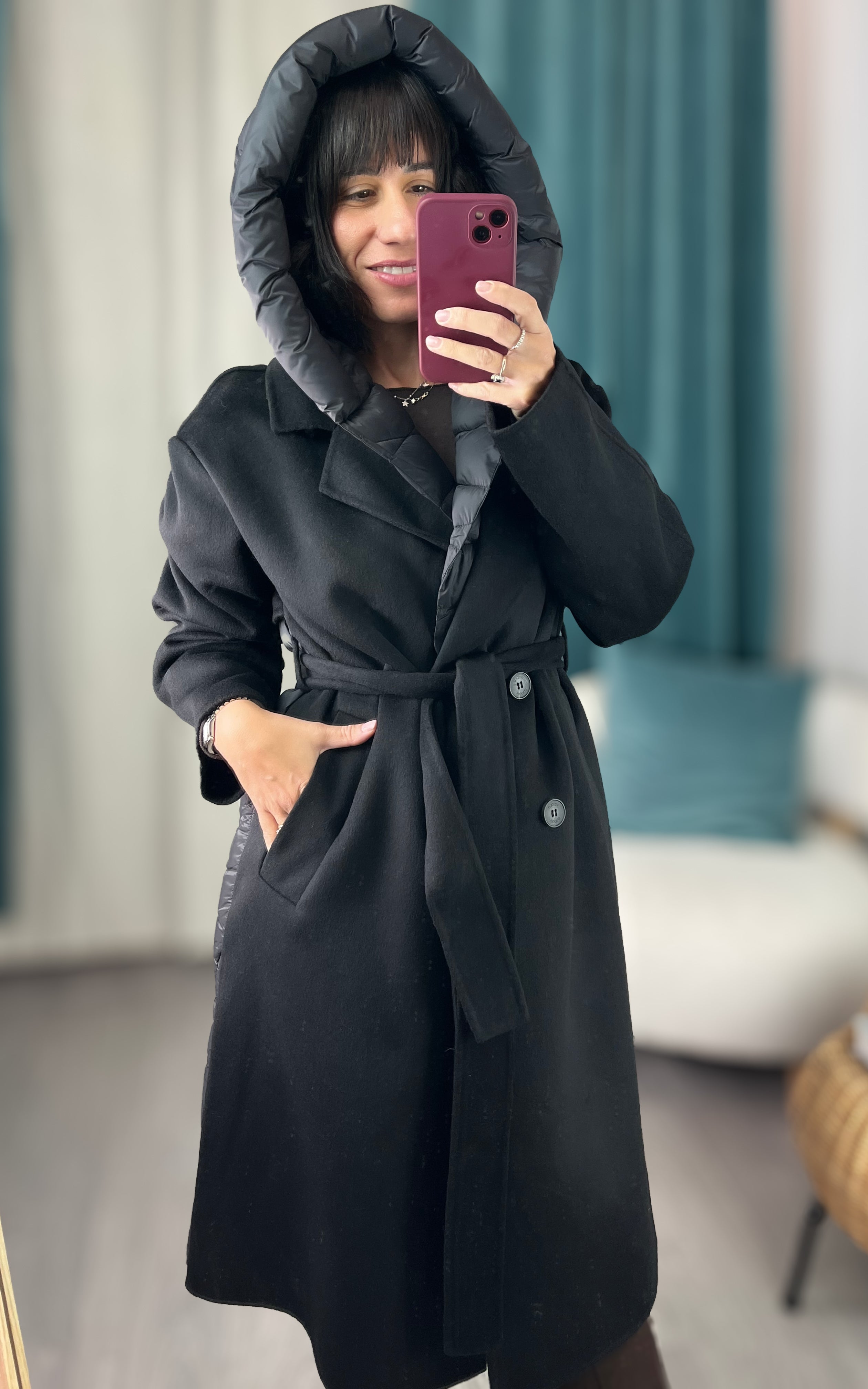 Alice indossa il cappotto nero Vicolo con cappuccio removibile e cintura, vista frontale.