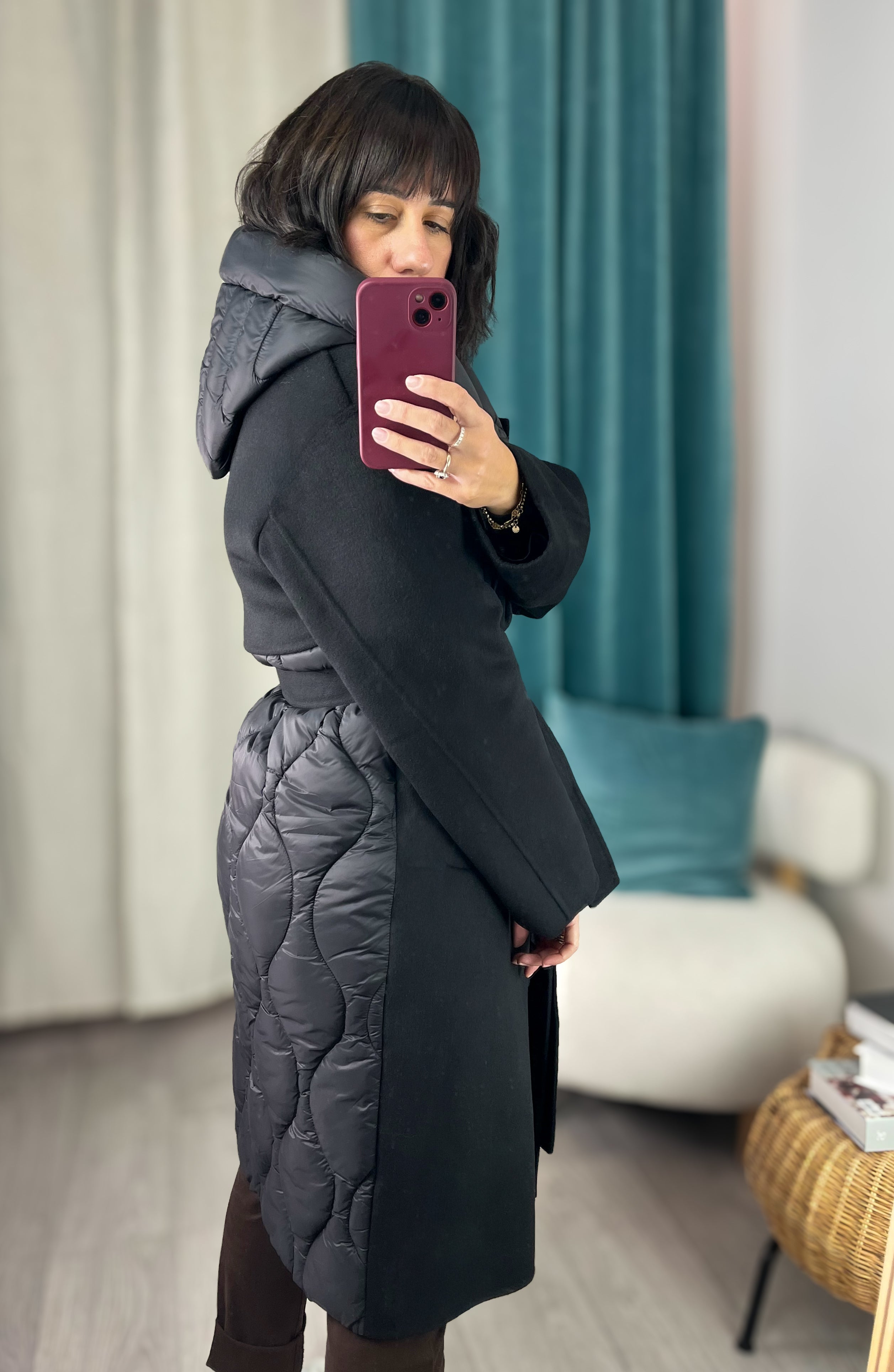 Alice mostra il cappotto nero Vicolo con inserti laterali in piumino, vista laterale.