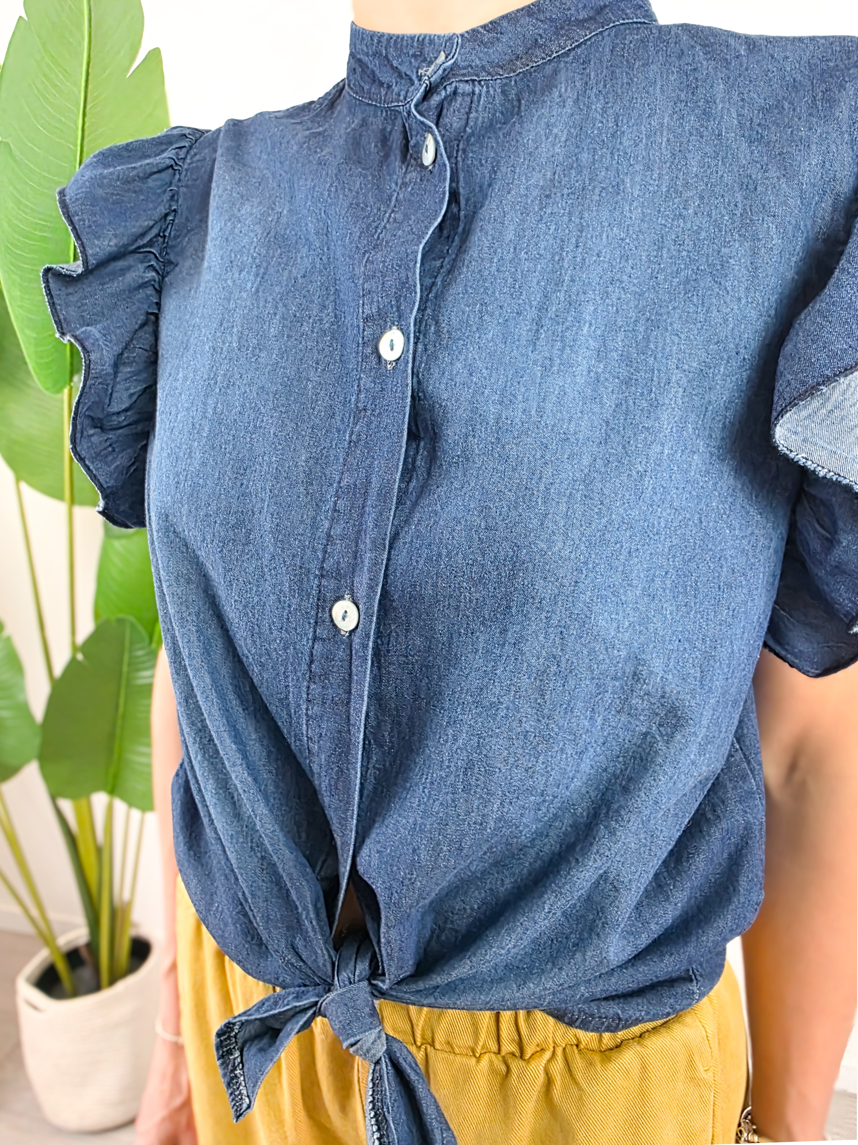Dettaglio della camicetta Susy Mix in tessuto chambray blu con bottoncini frontali e maniche ad aletta
