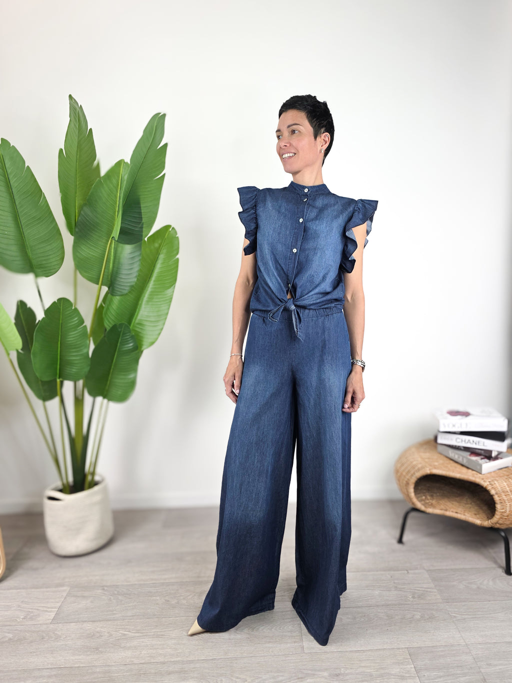 Modella indossa camicetta Susy Mix in chambray blu con maniche ad aletta e pantalone coordinato