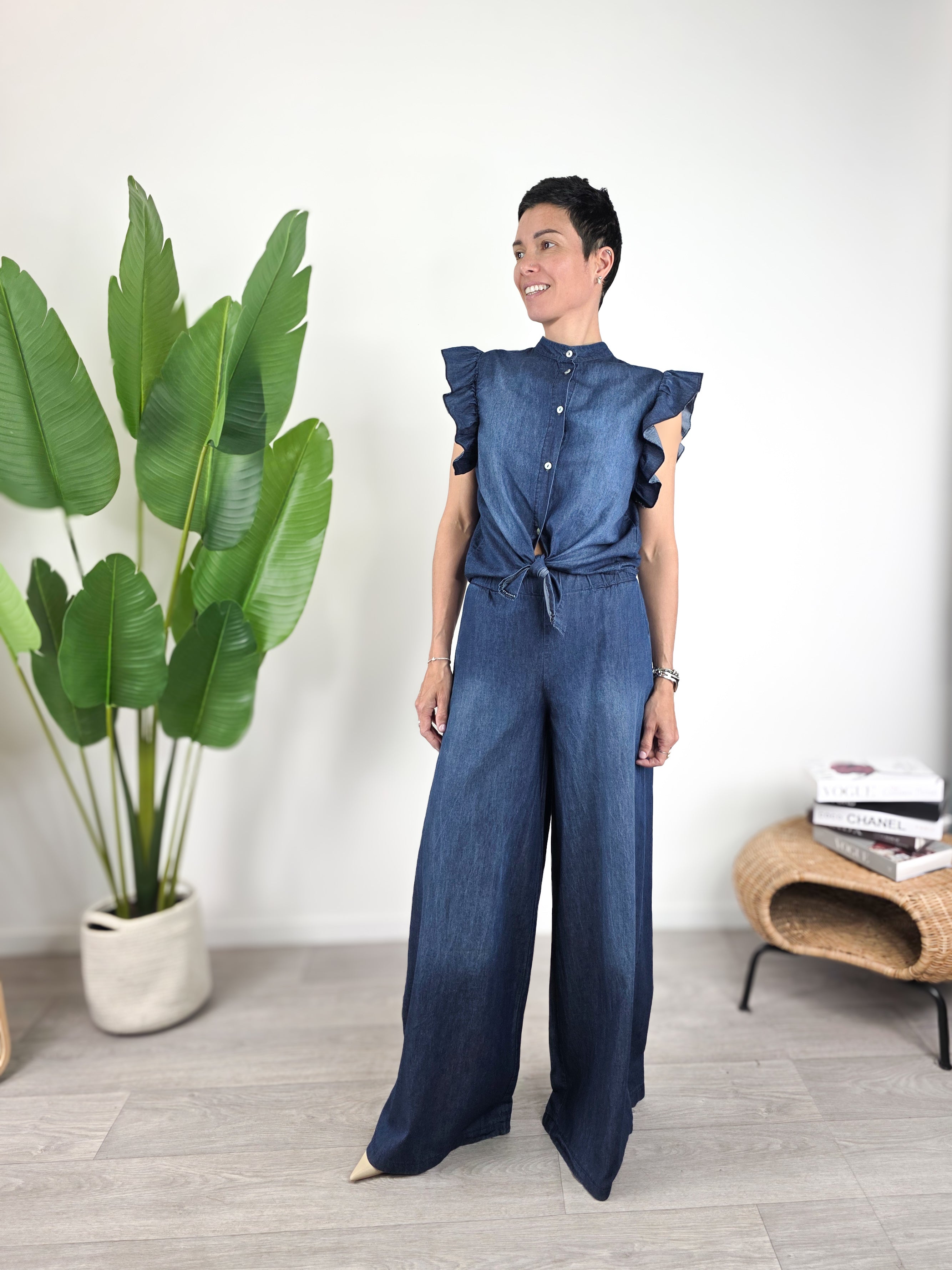 Modella indossa camicetta Susy Mix in chambray blu con maniche ad aletta e pantalone coordinato
